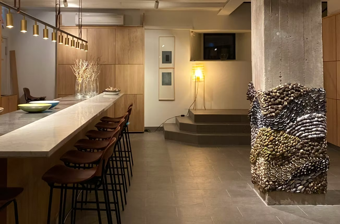 Modern interior with a bar area, stools, and decorative wall art.