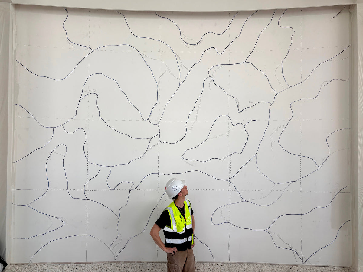 Buster Eriksson in front of the empty lobby wall with the flow sections drawn on it, Nammos Resort Amaala