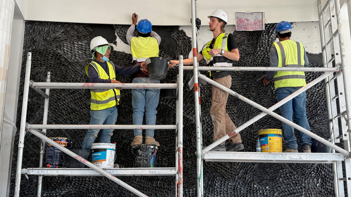 The installation team working on scaffolding near the top of the five-metre wall