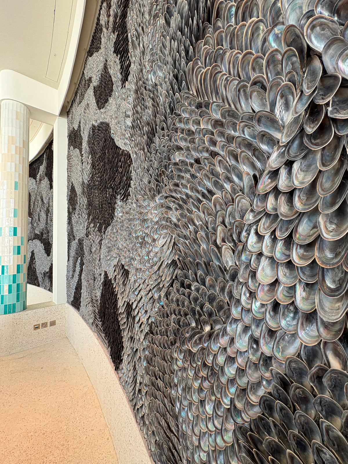 The curved shell wall in the hotel lobby beside a tiled column