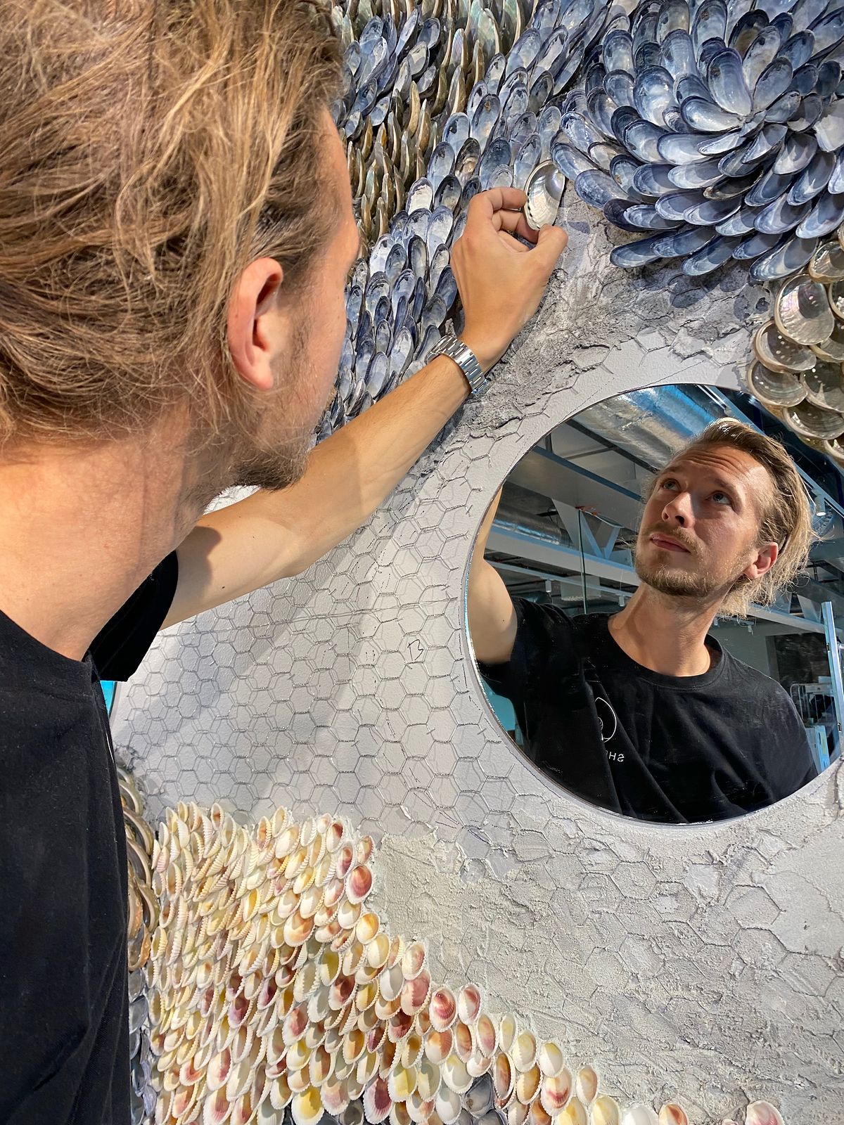Buster Eriksson placing a shell, reflected in one of the round mirrors